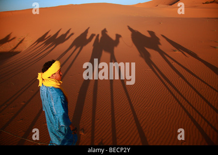 Blue Man in der Wüste, oder Tuareg Führer Kamele Touristen über Dünen Erg Chebbi in der Sahara in der Nähe von Fes, Marokko, Stockfoto