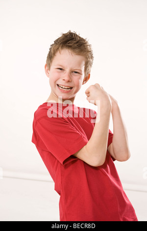 Junge mit geballten Fäusten schlagen eine Siegerpose Stockfoto