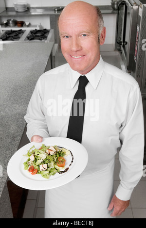 Kellner, die Halteplatte der Gemüsesalat Stockfoto
