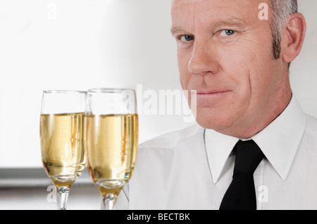 Kellner hielt ein Tablett mit Champagner-Flöten Stockfoto