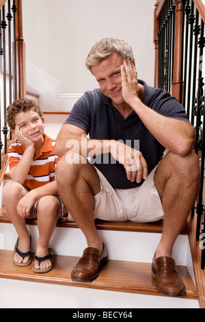 Man sitzt auf einer Treppe mit seinem Sohn und lächelnd Stockfoto