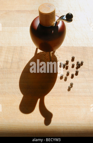Pfeffermühle, Brier Holz, Chrom, Schleifen, Griff und Füße, schwarze Pfefferkörner und gemahlenem Pfeffer auf Holz hacken board.color. Stockfoto