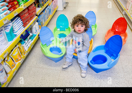 Baby Junge sitzt auf einer Toilette in einem Supermarkt Stockfoto