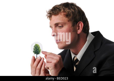 Geschäftsmann mit einem Baum in einer Lampe, vor einem weißen Hintergrund isoliert Stockfoto