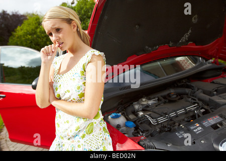 Besorgt Mädchen mit aufgeschlüsselt Auto Stockfoto