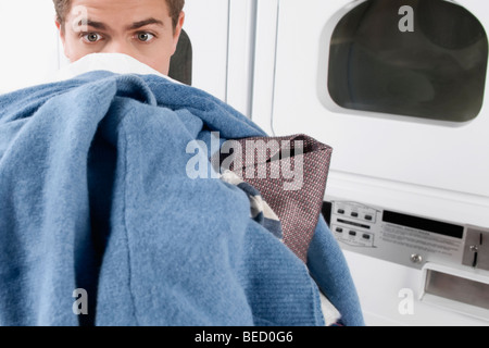 Mann trägt Kleidung in einem Waschsalon Stockfoto