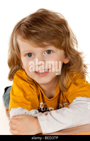 Drei-jähriger Junge liegend auf dem Bauch Lächeln Stockfoto
