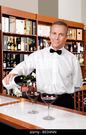 Kellner gießt Rotwein in Wein Gläser in einer bar Stockfoto