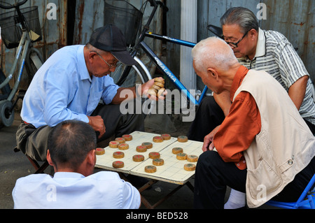 Männer spielen chinesisches Schach in einer Hutong-Straße, Peking, CN Stockfoto