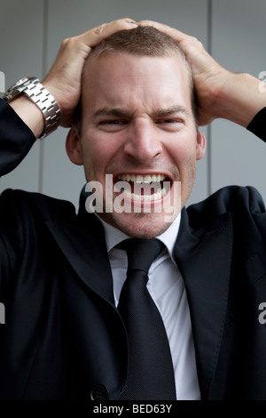 Geschäftsmann Kopf haltend und schreien Stockfoto