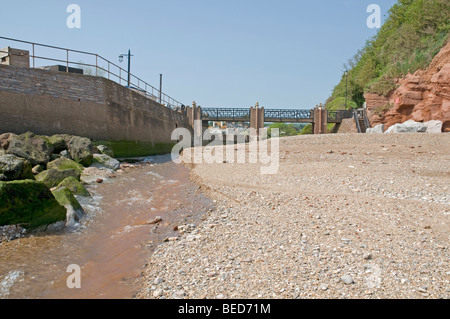 Die Fluss-Sid fließt seewärts über den steinigen Beah bei Sidmouth an der Südküste von Devon Stockfoto