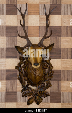 Plastic Hirschkopf montiert auf Nachahmung Holz Tapete, Frontalansicht Stockfoto
