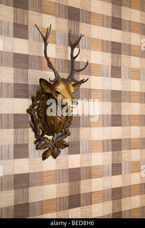 Plastic Hirschkopf montiert auf Nachahmung Holz Tapete, Seitenansicht Stockfoto