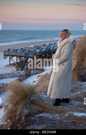 Winter auf der Insel Sylt, Frau den Sonnenuntergang im stehen am Rotes Kliff, Kampen, Sylt, Nordfriesischen Inseln, Schleswig-Holstein Stockfoto