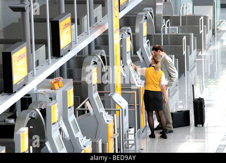 Lufthansa-Mitarbeiter erklären, ein Passagier der Quick-Check-in-Terminal von Lufthansa, Terminal 2 des Münchner Flughafens, Franz-Jose Stockfoto