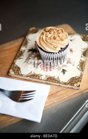 Ein Peanut Butter Cupcake und Espresso-Kaffeemaschine im Herzen Buchanan Deli und Café auf Byres Road im West End von Glasgow, Schottland. Stockfoto