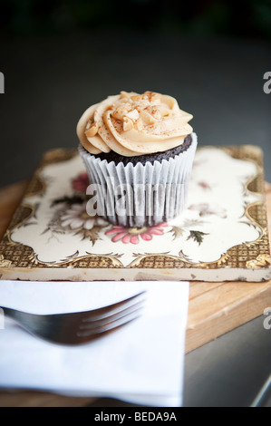 Ein Peanut Butter Cupcake und Espresso-Kaffeemaschine im Herzen Buchanan Deli und Café auf Byres Road im West End von Glasgow, Schottland. Stockfoto