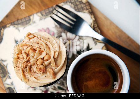 Ein Peanut Butter Cupcake und Espresso-Kaffeemaschine im Herzen Buchanan Deli und Café auf Byres Road im West End von Glasgow, Schottland. Stockfoto