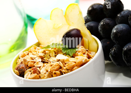 Früchte-Müsli, Äpfel und Trauben in eine Schüssel geben Stockfoto