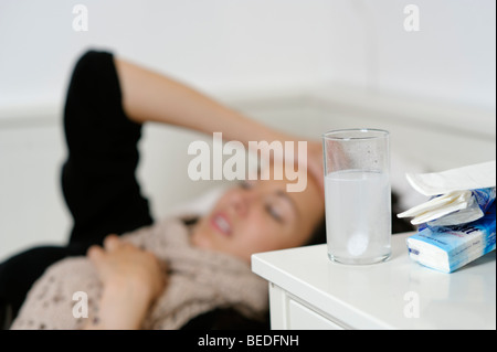 Junge Frau liegen im Bett mit einem Husten, Kälte, Grippe, schlecht Stockfoto