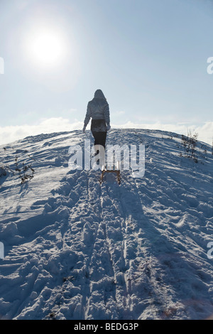 Junge Frau ziehen Schlitten im Schnee Stockfoto