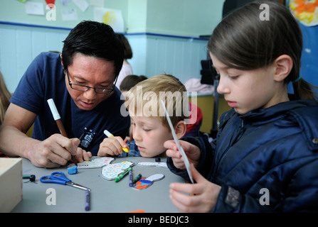 KINDER, DIE ZEICHNUNG AUF AUSSCHNEIDEN SCHMETTERLINGE AN EINEM SONNTAG SCHOOL UK Stockfoto