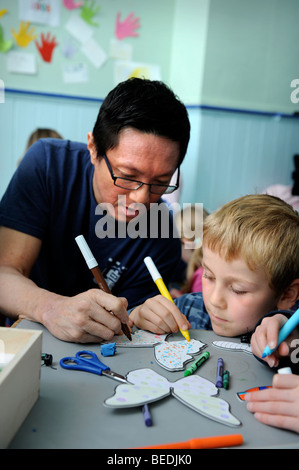 KINDER, DIE ZEICHNUNG AUF AUSSCHNEIDEN SCHMETTERLINGE AN EINEM SONNTAG SCHOOL UK Stockfoto