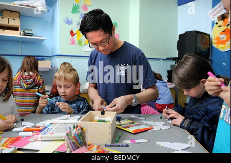 KINDER, DIE ZEICHNUNG AUF AUSSCHNEIDEN SCHMETTERLINGE AN EINEM SONNTAG SCHOOL UK Stockfoto