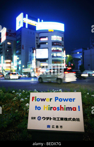 Schild mit der Aufschrift "Flower Power nach Hiroshima" 64 Jahre nach der ersten Atombombe verwendet wurde, um die Stadt auszulöschen. Stockfoto