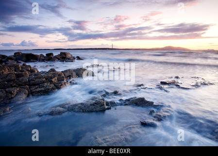 Sonnenuntergang mit Blick auf Holyhead Mountain gesehen hier von Porth Penrhyn-Mawr auf die Isle OF Anglesey. Stockfoto