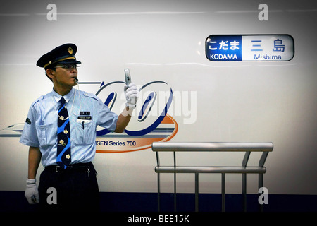 Ein Zugführer signalisiert Kollegen vor einem Kodama Klasse high-Speed Hochgeschwindigkeitszug in Tokio, Japan. Stockfoto