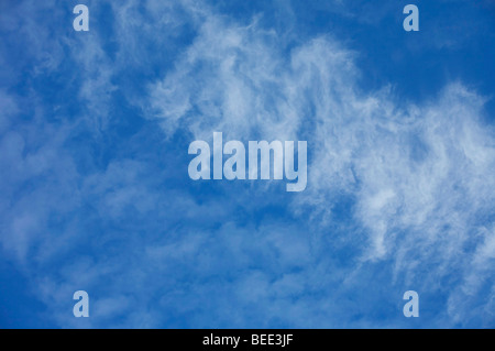 Strahlend blauer Himmel mit weißen Wolkenfetzen Stockfoto