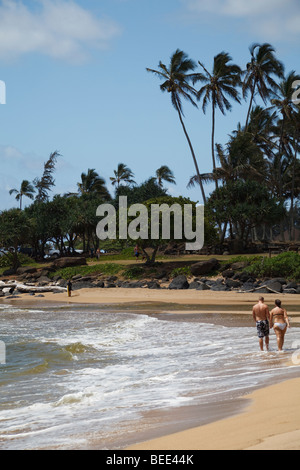 Ein paar, ein Spaziergang in der Brandung am Strand von Kauai Stockfoto