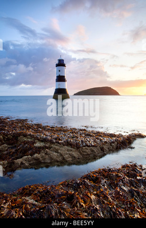 Ein Blick auf Penmon Leuchtturm und Puffin Island in der Morgendämmerung auf der Küste von Anglesey in Nord-Wales. Stockfoto