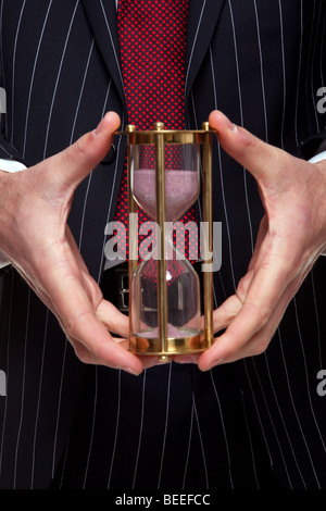 Aufnahme eines Geschäftsmannes halten Messing Sand Timer oder Sanduhr hautnah Stockfoto