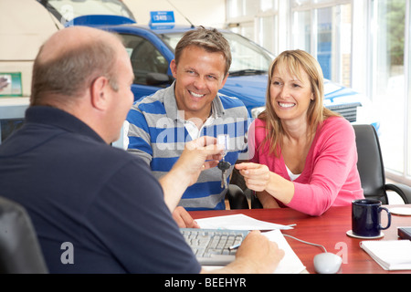 Paar ausfüllen Papierkram im Autohaus Stockfoto