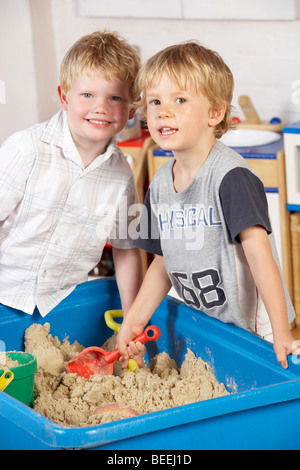 Zwei Jungen spielen zusammen im Sandkasten Stockfoto