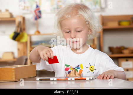 Erwachsenen hilft kleinen Kindern bei Montessori/Pre-School Stockfoto