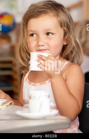 Kleiner Junge mit Tee bei Montessori/Pre-School Stockfoto