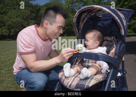 Chinesischen Vater und Baby im Kinderwagen im park Stockfoto