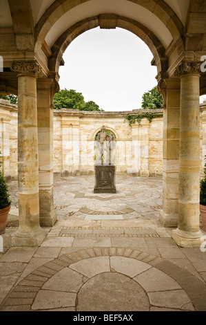 Ein italienisches Statue gesehen durch einen Torbogen in der Hever Castle Gardens. Stockfoto