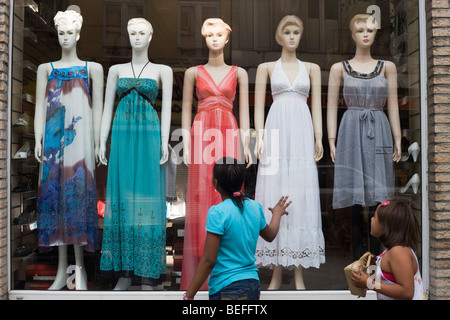 Zwei einheimische Kinder bewundern eine Line-up von Kleid Mode Schaufensterpuppen auf dem Display in einem Straße Schaufenster von Saint-Gilles, Brüssel Stockfoto