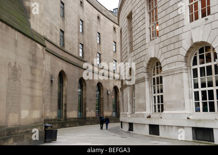 Zwei junge Menschen, die zwischen den historischen Gebäuden der Manchester Town Hall und Zentralbibliothek Stockfoto