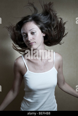 Studio-Porträt der jungen Frau mit Haaren in der Luft schweben. Stockfoto