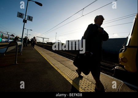 Silhouette der Passagiere zu Fuß entlang einer Bahn-Bahnsteig in England. Stockfoto