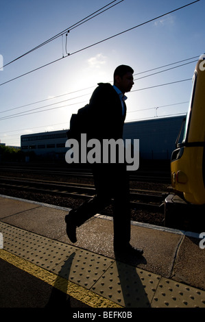 Silhouette des Passagiers zu Fuß entlang einer Bahn-Bahnsteig in England. Stockfoto