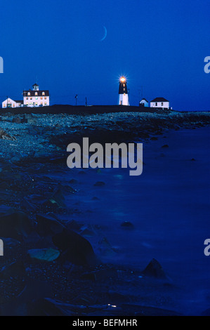 Point Judith Leuchtturm Narragansett, Rhode Island auf felsigen Küstenlinie in der Abenddämmerung Stockfoto