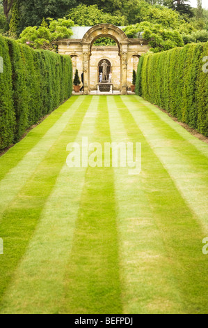 Ein italienisches Statue gesehen durch einen Torbogen in der Hever Castle Gardens. Stockfoto