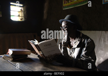 Bakonzo Mann Sylvestra Lesebuch "Stamm" von Tom Stacey, in dem er Schlüsselrolle, Ruwenzori-Gebirge, West-Uganda, Afrika spielt Stockfoto