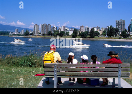 Vancouver, BC, Britisch-Kolumbien, Kanada - Familie sitzt auf der Bank im Vanier Park, mit Blick auf English Bay und West End, Sommer Stockfoto